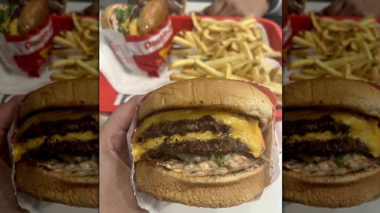A hand holding an In-N-Out Double-Double burger