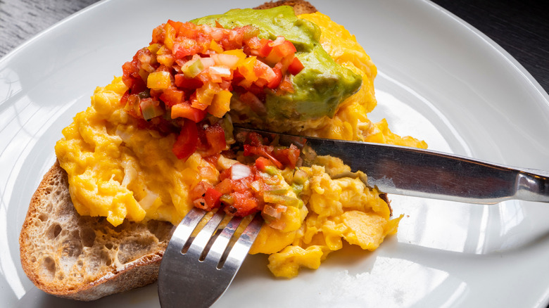 scrambled eggs with salsa and guacamole on toast