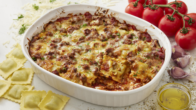 Dish of baked ravioli lasagna with fresh ravioli and tomatoes