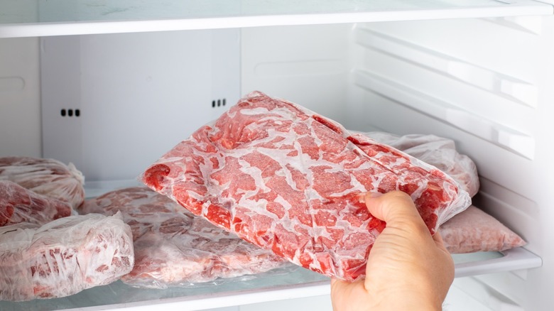 frozen flat ground beef being removed from freezer