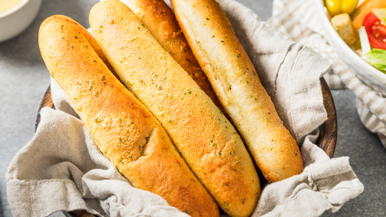 close up of homemade garlic breadsticks in basket