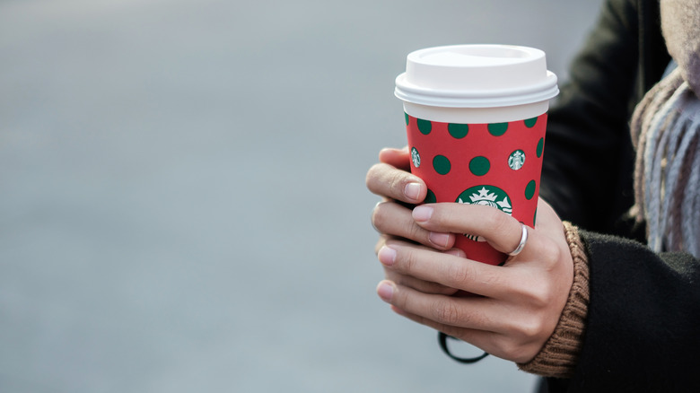 Woman's hands holding Starbucks holiday cup
