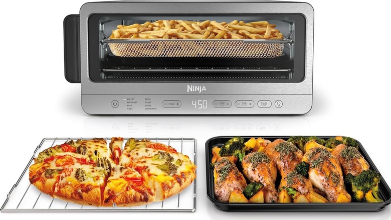 Ninja Flip toaster oven filled with fries with two trays in front