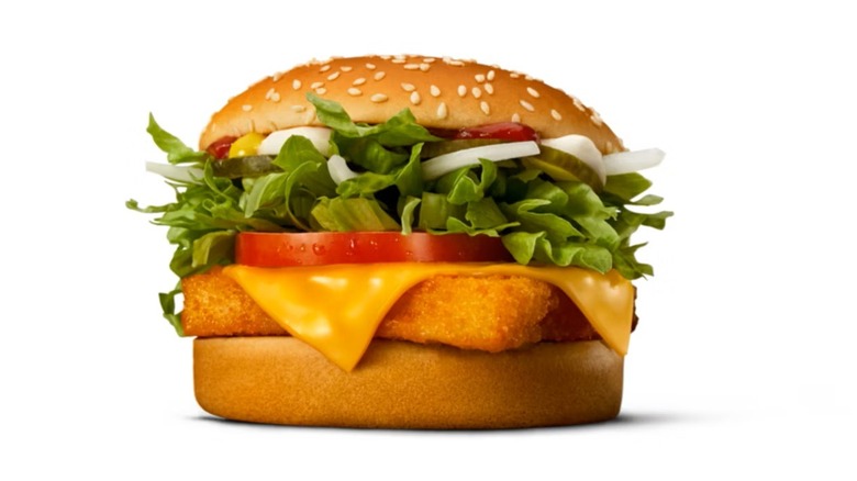 A McDonald's Fish McFeast, featuring a fried fish patty topped with cheese, lettuce, tomato, onion, pickles, and sauce on a sesame seed bun