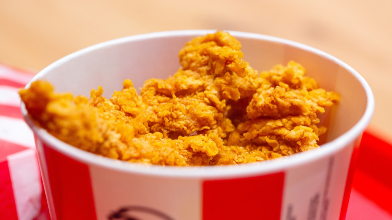 KFC's signature red and white cardboard bucket filled with fried chicken