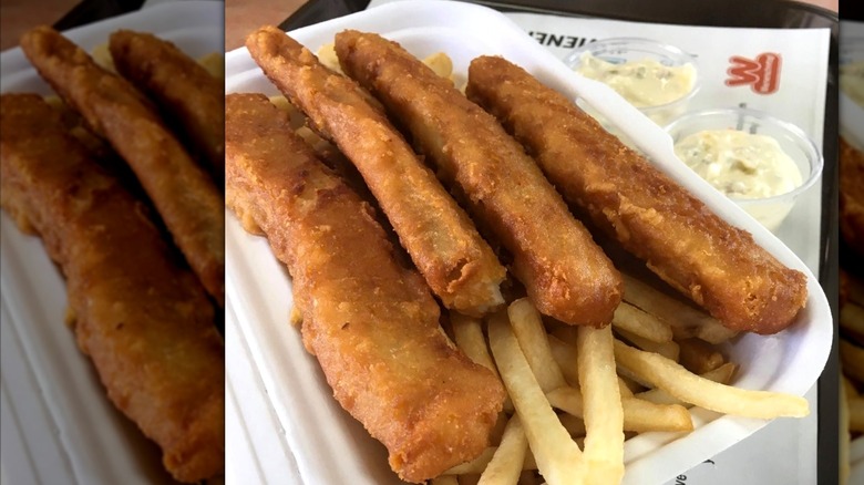 White container of Wienerschnitzel Fish 'n Chips with two plastic cups of tartar sauce on side