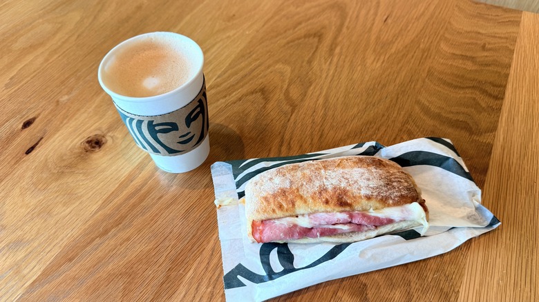 Ham & Swiss on Baguette and Flat White on table
