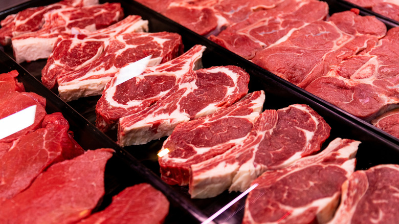 A close-up of raw steaks out for sale in a grocery store.