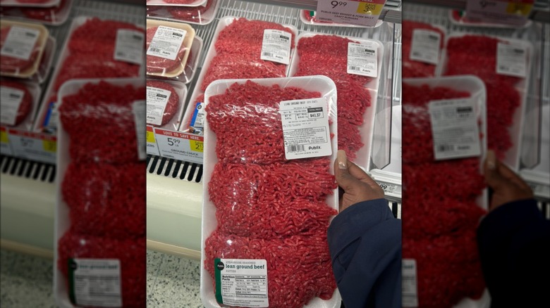 A customer holds a package of overpriced ground beef at Publix.