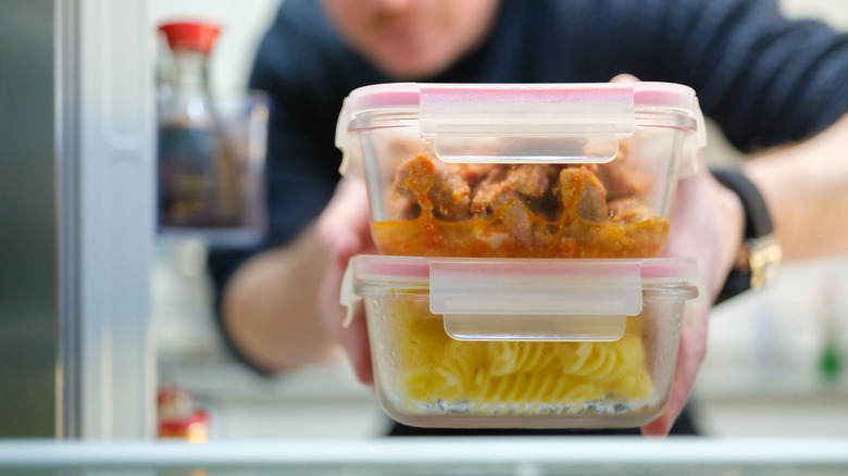 Someone taking food storage containers out of a refrigerator