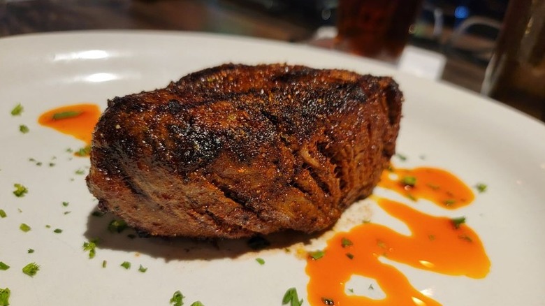 steak filet on plate with orange sauce