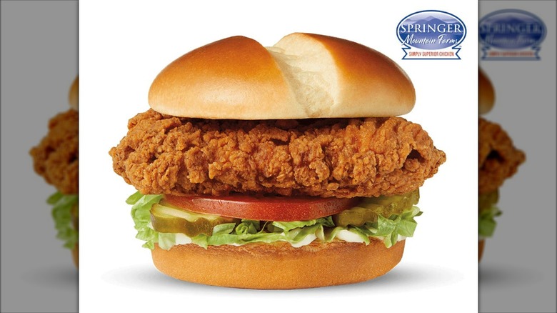 Crispy chicken sandwich with lettuce, tomato, pickles, and mayo