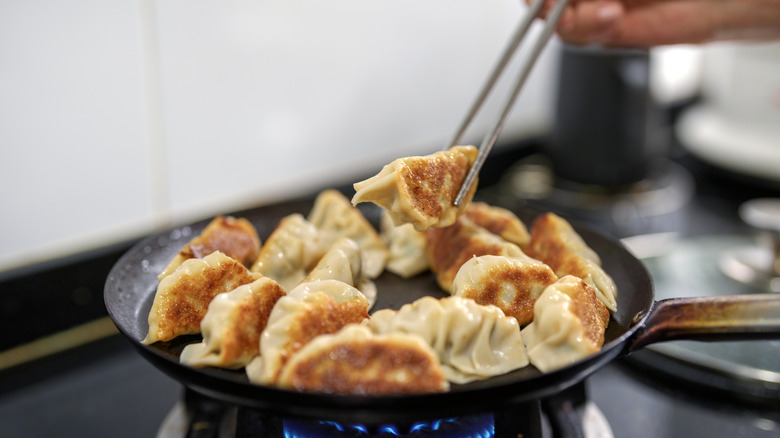 close up of dumplings on hob in a pan