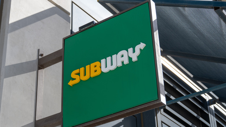 Green Subway sign hanging from building