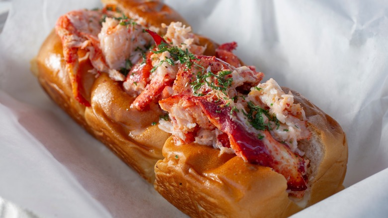 Plump lobster roll resting in white paper