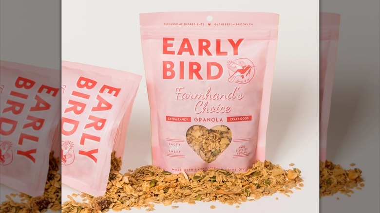 Two bags of Early Bird Farmhand's Choice Granola, surrounded by granola out of one bag