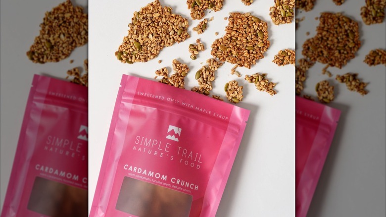 Overhead shot of Simple Trail Cardamom Crunch granola bag with chunks spread out on surface underneath