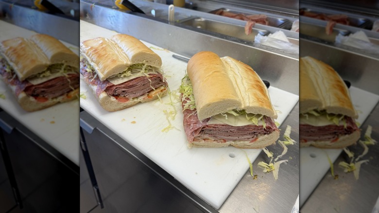 two halves of gargantuan sandwich on chopping board, mirrored image