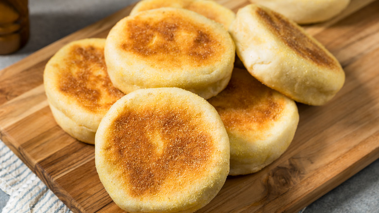 English muffins stacked on wooden board