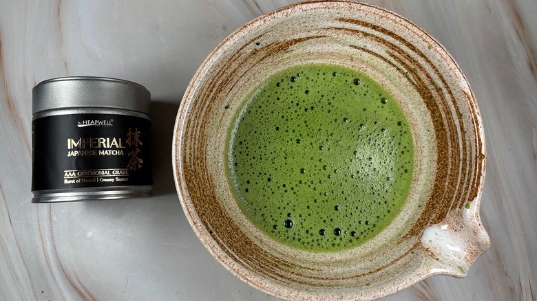 Matcha in beige chawan next to Heapwell Imperial Matcha tin