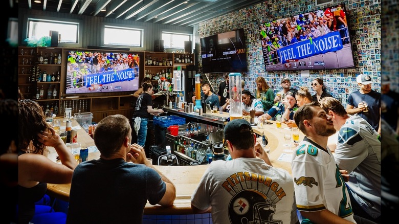 Fans around a U-shaped bar watching TV