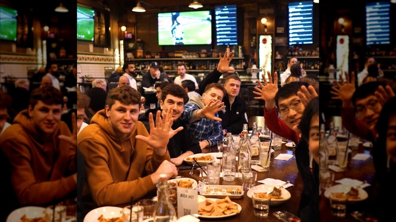 Group sitting at a table filled with food and drinks at the Queen Anne Beerhall