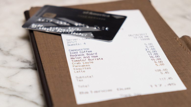 a receipt from a cafe with a credit card on top of it