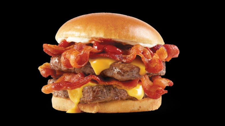 A Wendy's Baconator on a black background