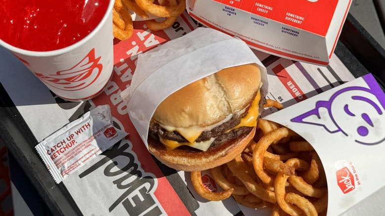 Jack in the Box Ultimate Cheeseburger with fries and a drink on tray