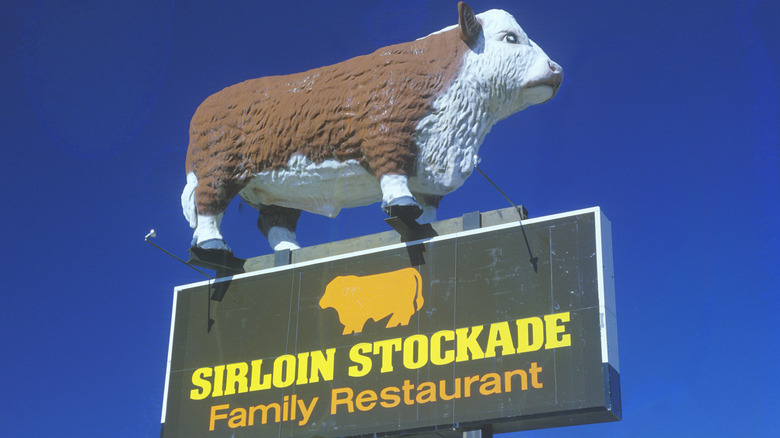 Exterior sign for Sirloin Stockade with cow mascot on top