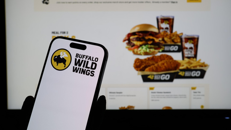Buffalo Wild Wings app on smartphone in front of web site