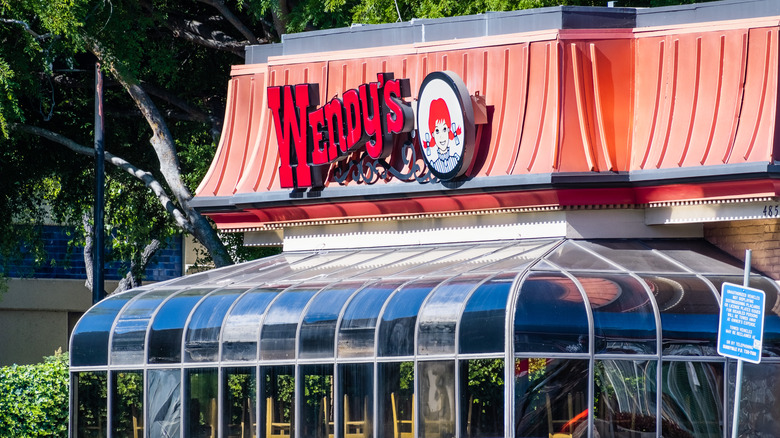 The exterior of a Wendy's restaurant with a sunroom out front