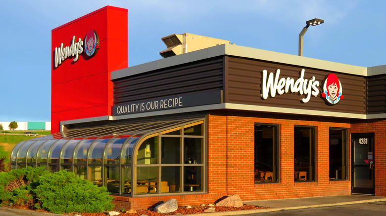 The exterior of a Wendy's with a solarium in the front
