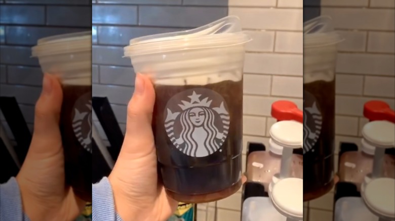 mirrored image of hand holding Nitro Cold Brew With Salted Honey Cold Foam