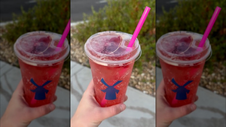 Handholding watermelon fizz drink Dutch Bros with a pink straw