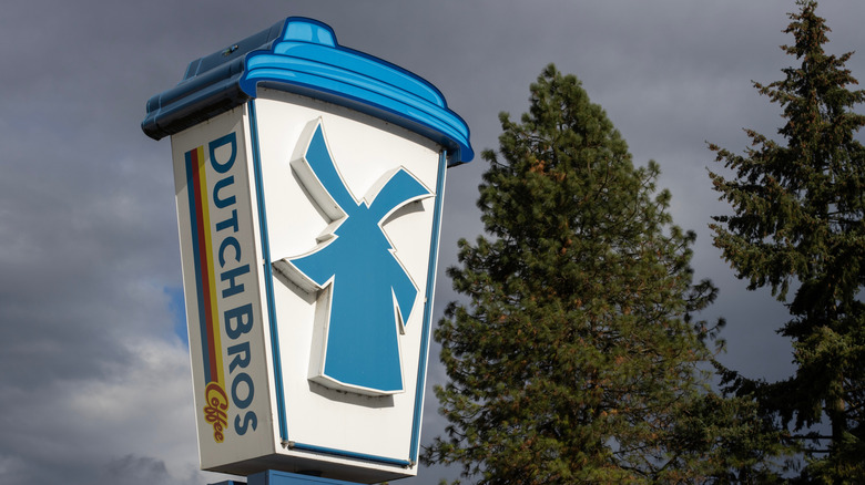Dutch Bros sign outside of a coffee shop with trees in the background