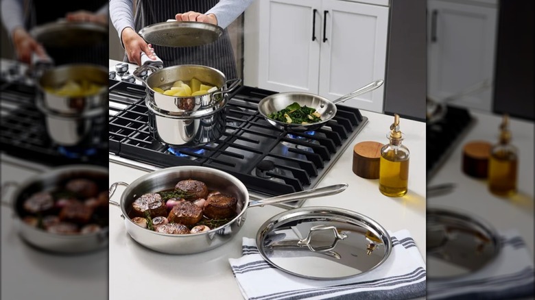 All-Clad D3 cookware set on a stovetop and countertop with ingredients