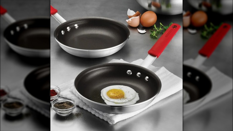 Two Tramontina professional non-stick aluminum pans on a countertop with eggs and other ingredients