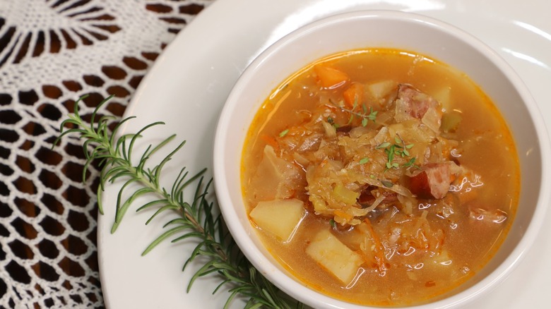 Bowl of sauerkraur soup with sprig of rosemary