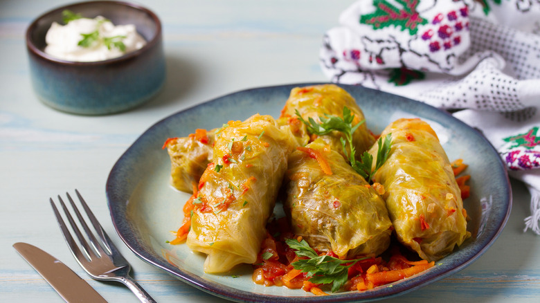 Stuffed cabbage rolls on pottery plate withsilverware