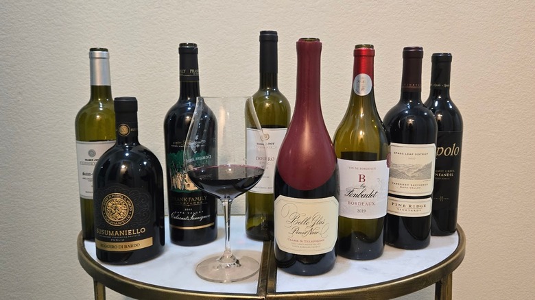 Bottles of red wine available at Trader Joe's and wine glass