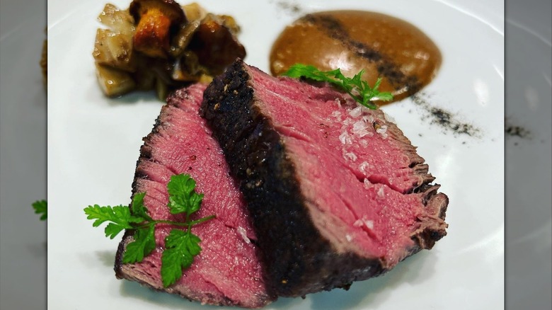 Top-view image of two white bowls with greens, mushrooms, poached egg, asparagus, and green salads