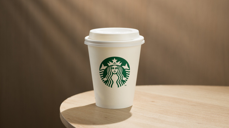 Starbucks drink in a classic paper cup on a table