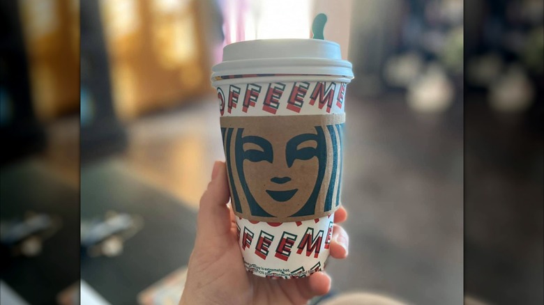 Holding Starbucks Honey Citrus Mint Tea in a classic paper cup