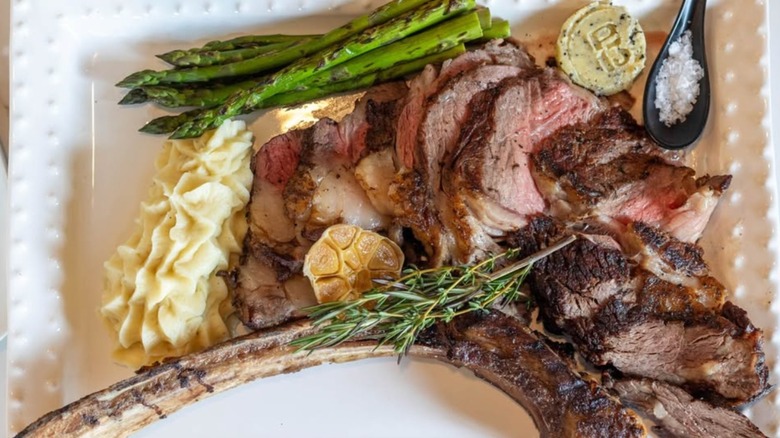 top view of steak dinner at Prime 13 with asparagus, potatoes, and garlic