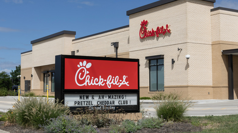Red Chick-fil-A sign in front of brick restaurant