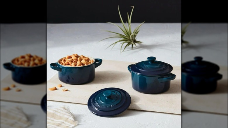 Le Creuset dark blue Mini Round Cocottes on countertop, with one pot filled with nuts