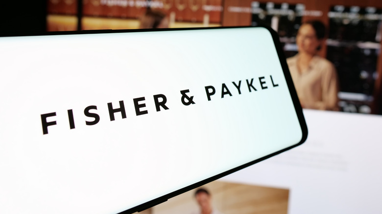 The Fisher & Paykel logo shown on a screen in a store with a person in the blurred background