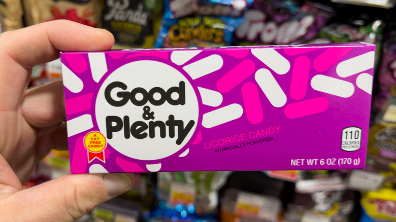 a hand holding a box of good & plenty