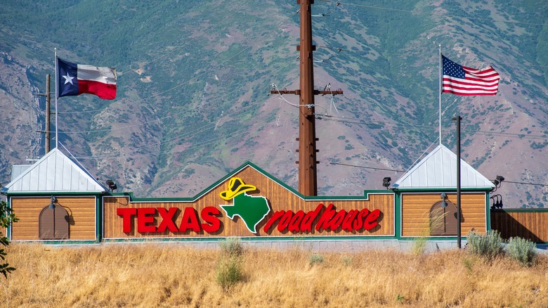 Exterior of a Texas Roadhouse location behind a hill